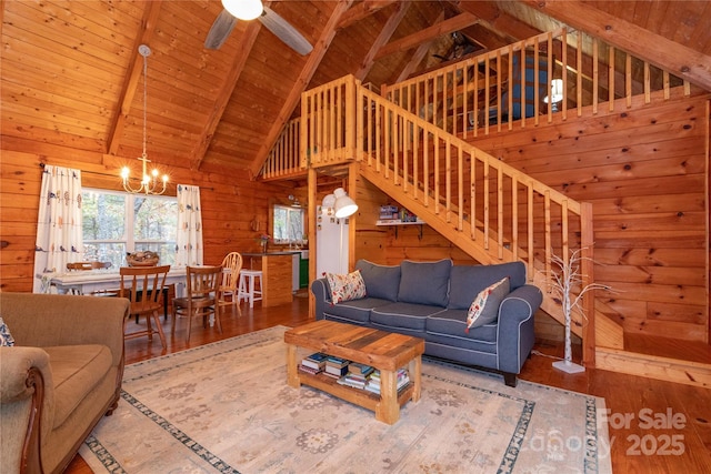 living room with beam ceiling, wood ceiling, wooden walls, and hardwood / wood-style flooring