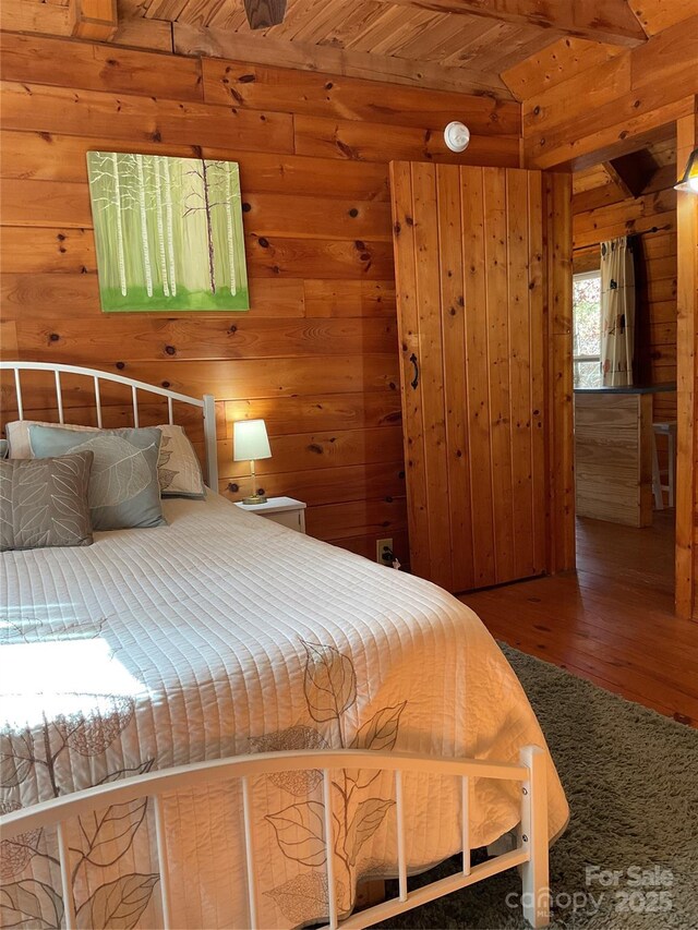 bedroom featuring wood-type flooring, wooden ceiling, and wood walls