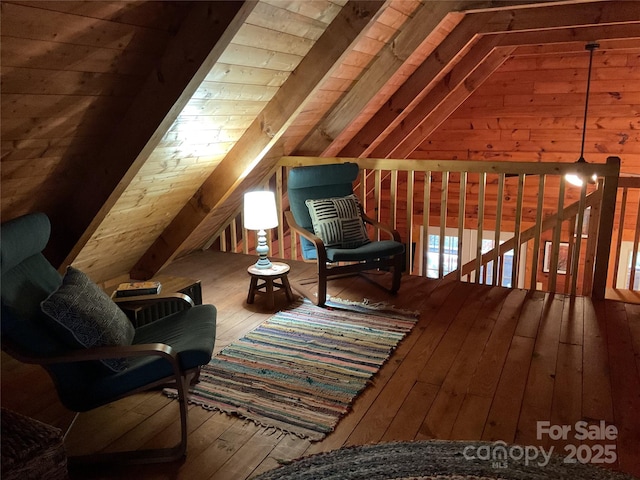 sitting room with hardwood / wood-style flooring, lofted ceiling, and wood walls