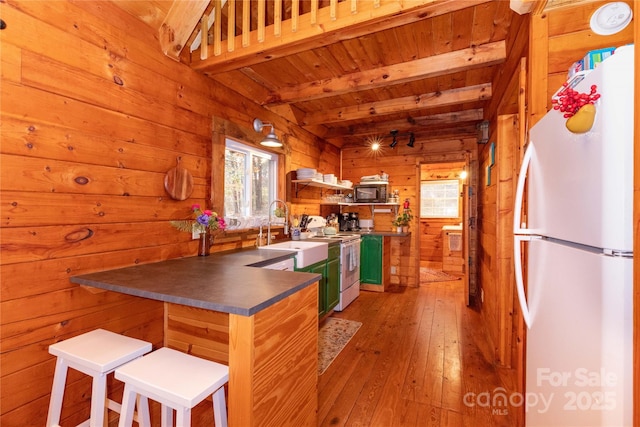 kitchen with sink, wood ceiling, wooden walls, white appliances, and beam ceiling