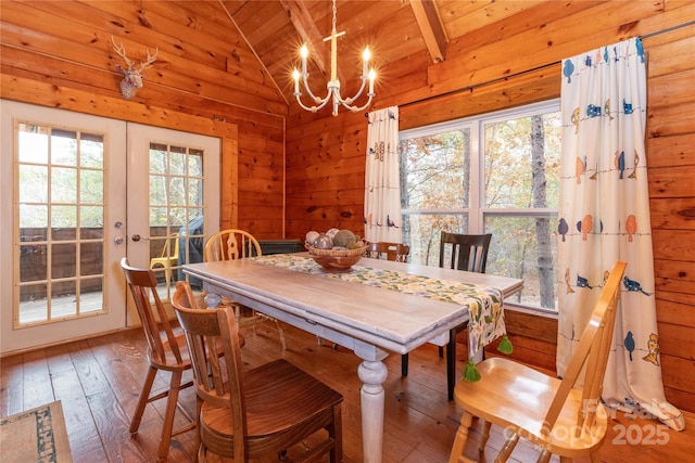 dining area featuring lofted ceiling, a healthy amount of sunlight, wood ceiling, and french doors