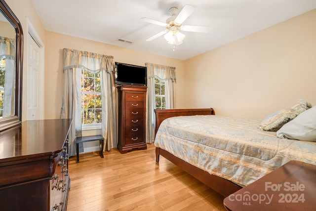 bedroom with light hardwood / wood-style floors, multiple windows, and ceiling fan