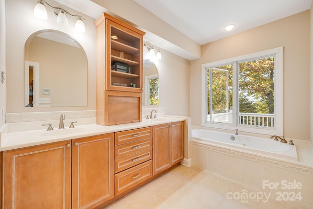 bathroom with tile patterned floors, vanity, and tiled tub