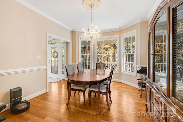 dining room featuring crown molding, light hardwood / wood-style floors, and an inviting chandelier