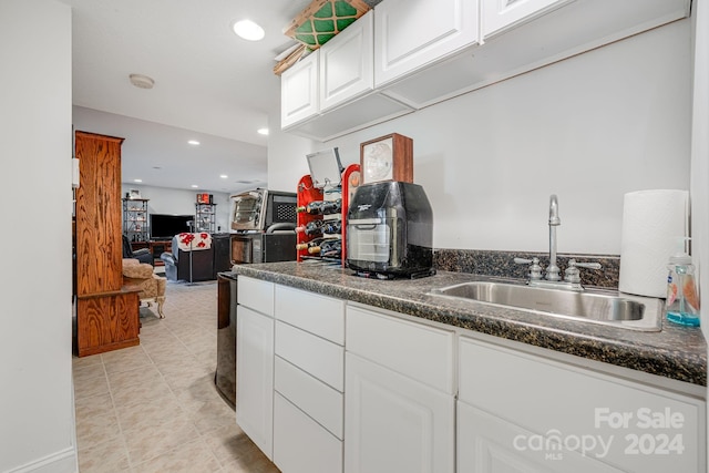 kitchen featuring white cabinetry, sink, and light tile patterned floors