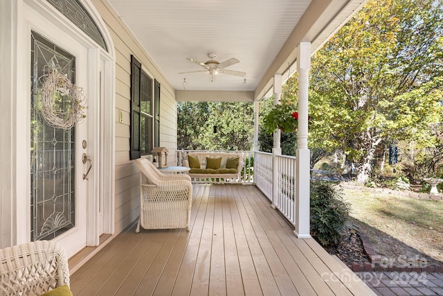 wooden terrace featuring covered porch and ceiling fan