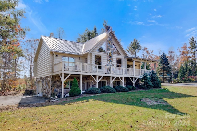 view of front facade with a wooden deck and a front lawn