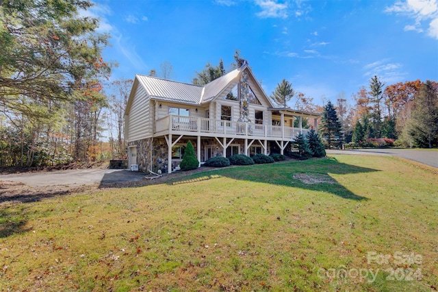 view of front of home with a front yard, a deck, and a garage