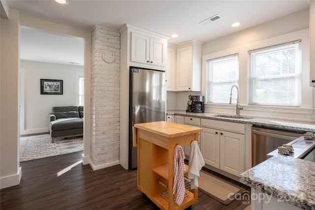 kitchen with white cabinets, stainless steel appliances, and dark hardwood / wood-style floors