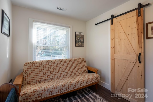 living area featuring a barn door and dark hardwood / wood-style flooring