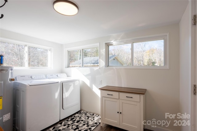 clothes washing area with separate washer and dryer, electric water heater, dark wood-type flooring, and a healthy amount of sunlight