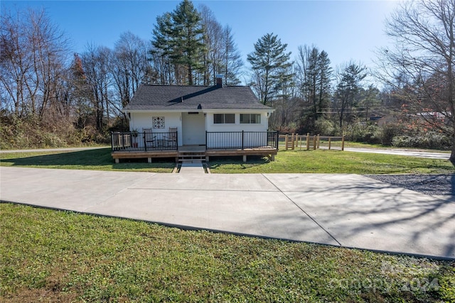 back of house with a deck and a lawn