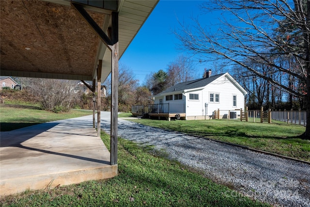 view of side of home with a lawn and a deck