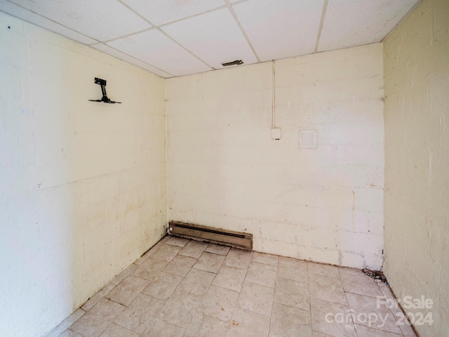 interior space featuring baseboard heating and a paneled ceiling