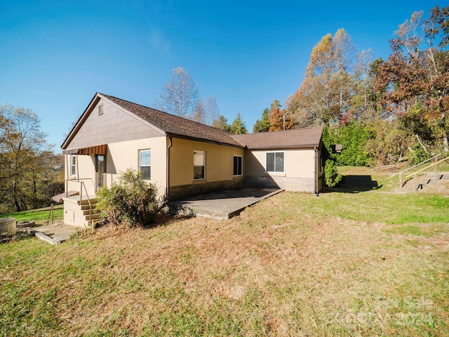 back of property with a yard and a patio area