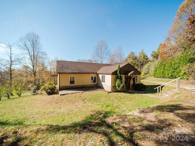 rear view of property featuring a yard and a patio