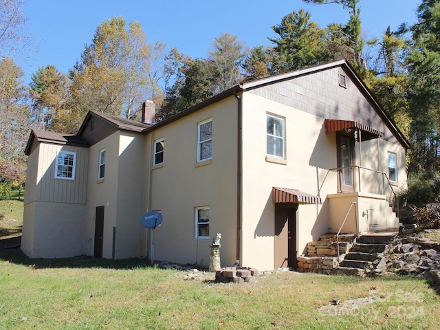 rear view of house featuring a yard