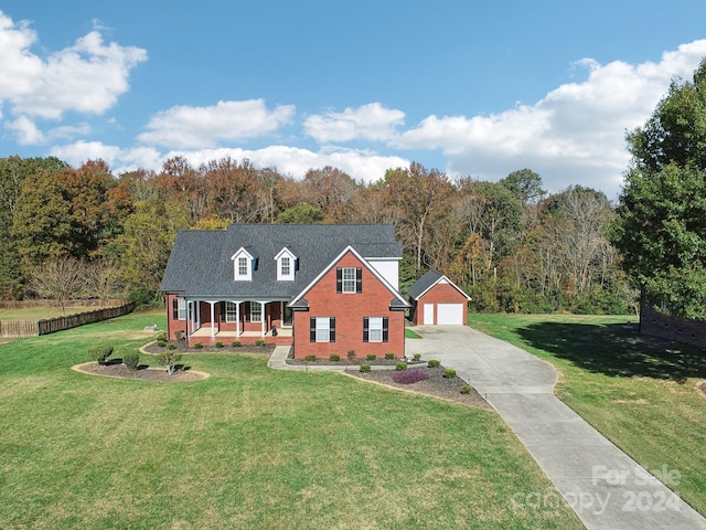 cape cod-style house with a garage, a front lawn, an outdoor structure, and a porch