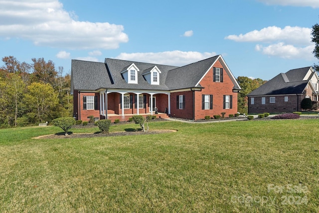 cape cod house featuring a front yard