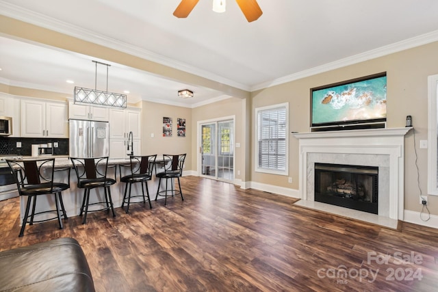 kitchen with dark hardwood / wood-style flooring, a kitchen island with sink, a kitchen breakfast bar, pendant lighting, and appliances with stainless steel finishes