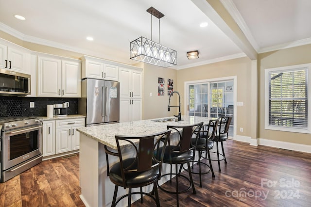 kitchen with premium appliances, sink, and an island with sink