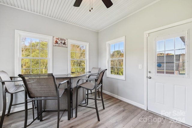 dining space with light hardwood / wood-style floors, ceiling fan, a wealth of natural light, and ornamental molding