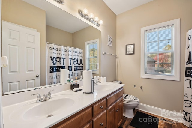 bathroom featuring hardwood / wood-style floors, plenty of natural light, vanity, and toilet