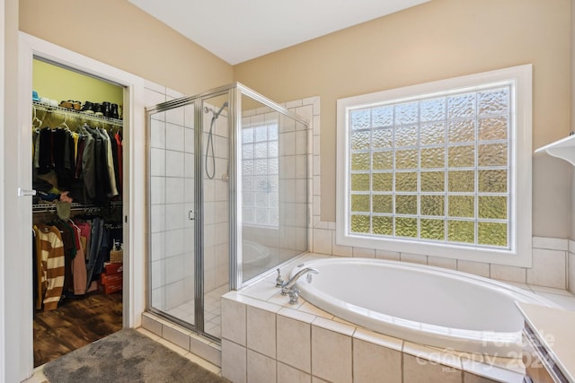 bathroom featuring independent shower and bath and wood-type flooring