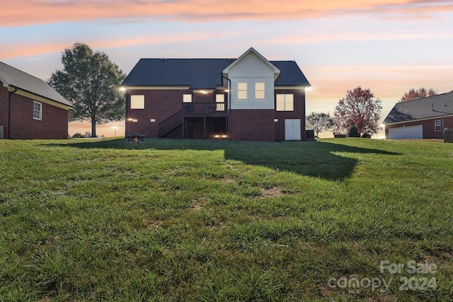 back house at dusk featuring a yard