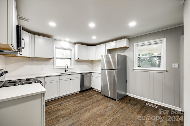 kitchen with white cabinets, stainless steel appliances, sink, and dark hardwood / wood-style flooring