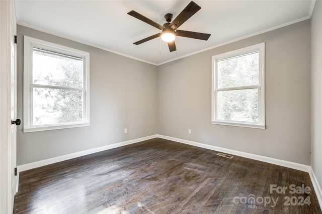 spare room featuring ceiling fan, a healthy amount of sunlight, and dark hardwood / wood-style flooring