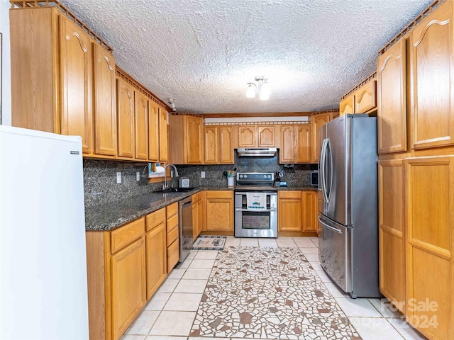 1000 Mountain View Church Rd, Zirconia, NC 28790 - kitchen with appliances with stainless steel finishes, light tile patterned floors, a sink, backsplash, and a textured ceiling