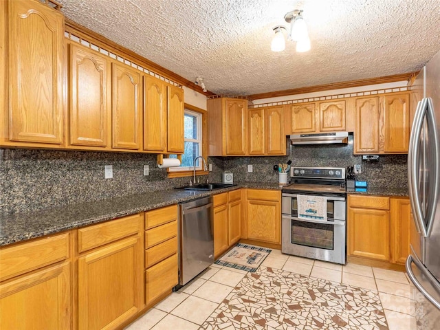 kitchen with appliances with stainless steel finishes, light tile patterned floors, and dark stone counters