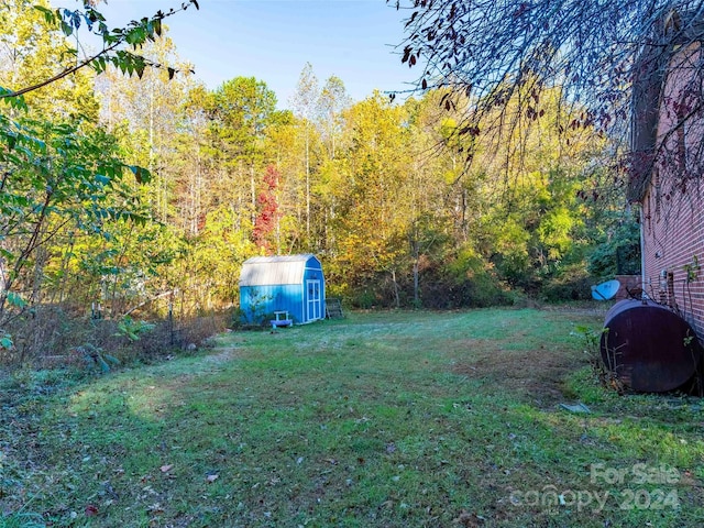 1000 Mountain View Church Rd, Zirconia, NC 28790 - view of grassy yard with a storage shed, an outbuilding, and a view of trees