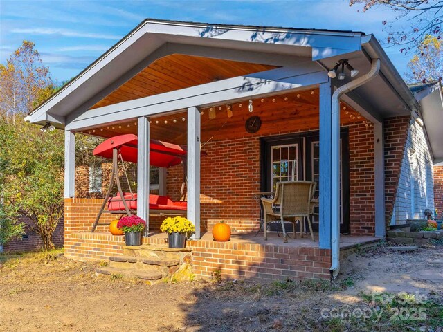 1000 Mountain View Church Rd, Zirconia, NC 28790 - back of house with brick siding and a porch