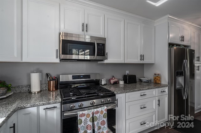 kitchen with white cabinets, light stone countertops, and stainless steel appliances