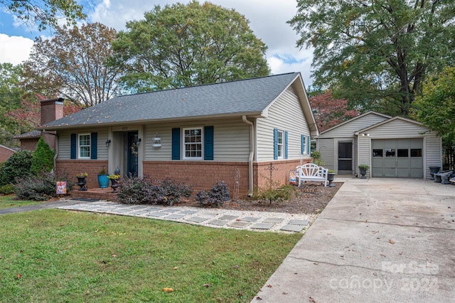 view of front facade featuring a front lawn, an outbuilding, and a garage