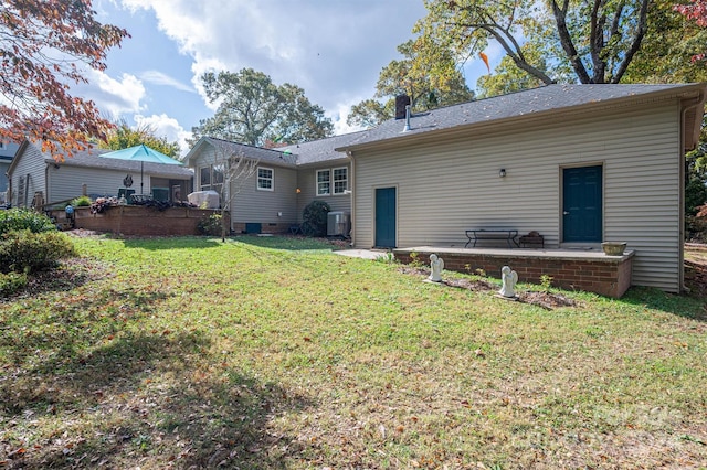 back of house with a patio and a lawn