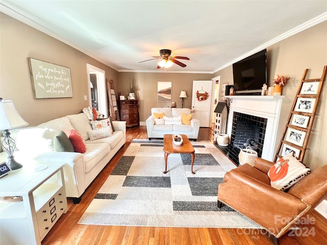 living room with ceiling fan, wood-type flooring, and ornamental molding