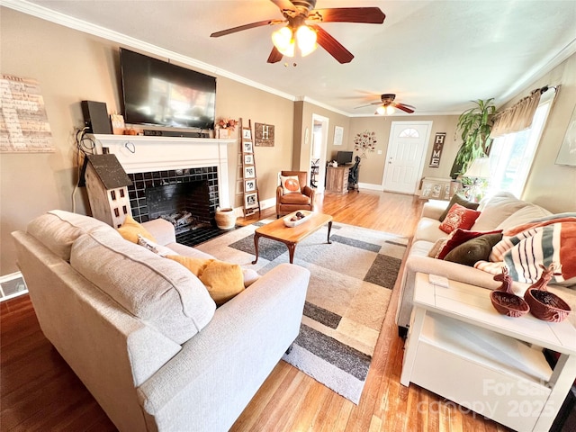 402 Sharon Ave, Lenoir, NC 28645 - living room featuring a tiled fireplace, baseboards, a ceiling fan, and ornamental molding
