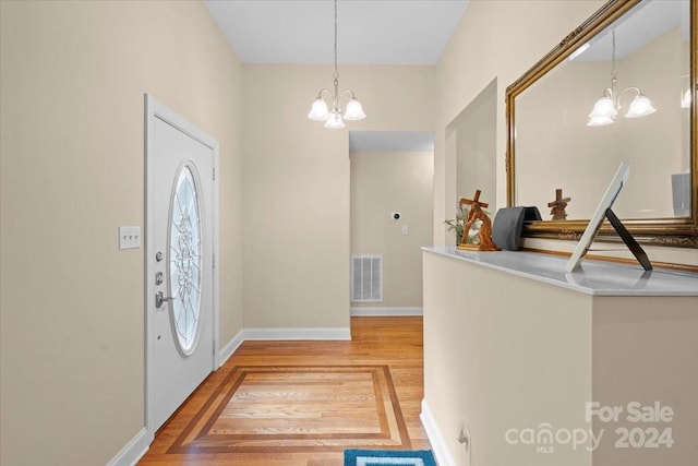 entryway featuring hardwood / wood-style flooring and an inviting chandelier