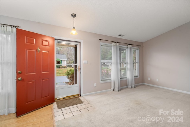 foyer featuring light colored carpet