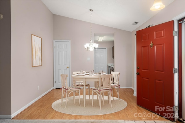 dining area featuring light wood-type flooring, lofted ceiling, and an inviting chandelier