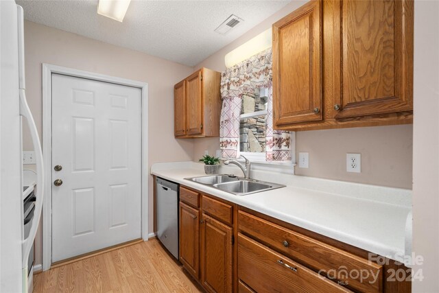 267 Rocky Mountain Way, Arden, NC 28704 - kitchen featuring a sink, stainless steel dishwasher, light wood-type flooring, brown cabinetry, and light countertops