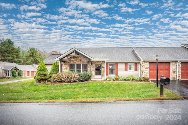 ranch-style house with a garage and a front lawn