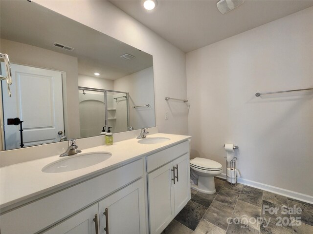 bathroom with toilet, a shower with shower door, and vanity