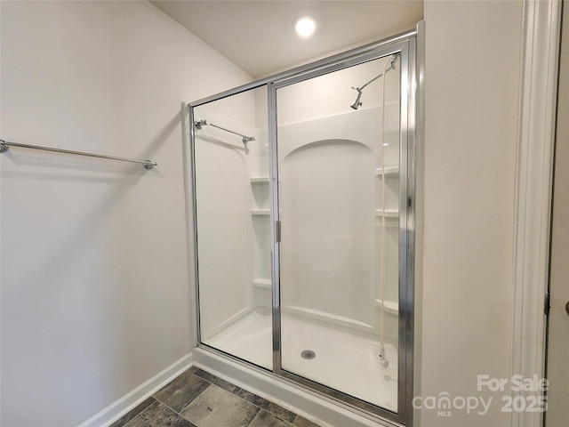 bathroom featuring a shower with door