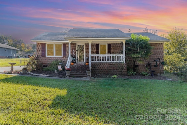 view of front of house with a yard and a porch