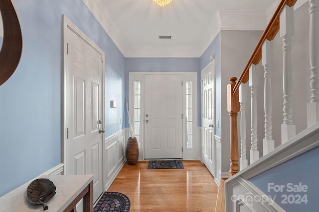 foyer entrance featuring ornamental molding and light hardwood / wood-style flooring