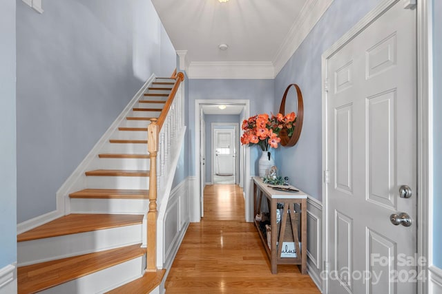 entrance foyer featuring light hardwood / wood-style floors and ornamental molding